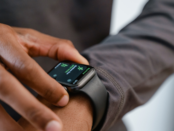 Person setting daily goals on smartwatch for wearable fitness preventive care, tracking steps and heart rate
