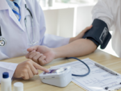 A blood pressure monitor displaying an elevated reading indicating high blood pressure.