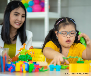 A young child with autism engaging in a playful therapy session, supported by a therapist