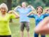 Group of diverse seniors engaging in outdoor exercise in a park.