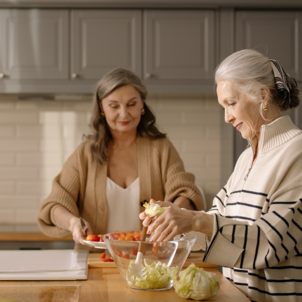 Two seniors preparing healthy food in a bright, modern kitchen.