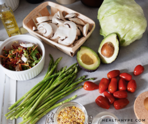 A plate with leafy greens, fresh berries, lean protein slices, and healthy fats.