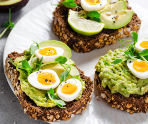 Healthy breakfast with brown bread, avocado, and eggs