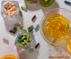 Various dietary supplement bottles and capsules displayed on a table.